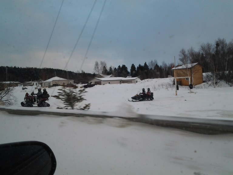 Quad equipped with tracks traveling on the Gander River.