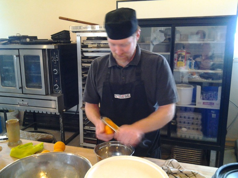 On two visits, I still haven't seen Curtis stand still long enough to get a proper picture. Here he's grating orange zest for the next batch of scones. Flat Earth Outpost, Shoal Bay, Fogo Island. 